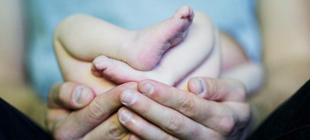 baby feet held by hands