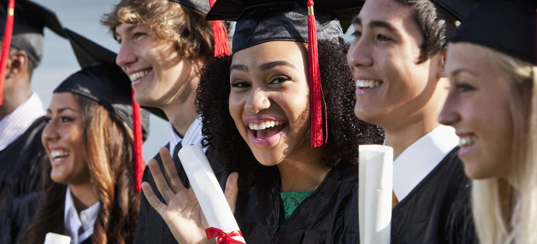 Line-of-high-school-graduates-holding-their-diplomas-at-their-graduation-ceremony