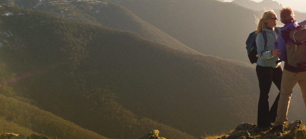 Mountain range behind a couple taking a selfie.