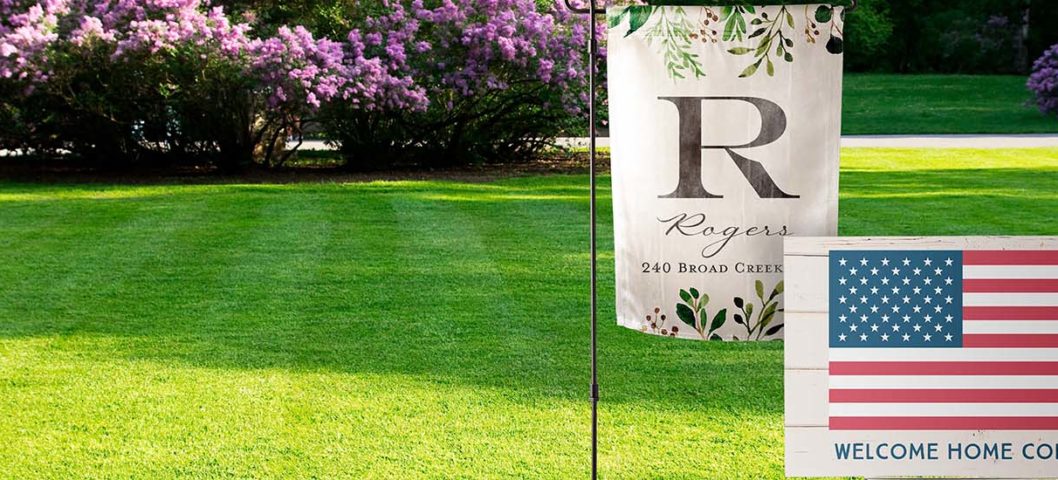 A garden flag and custom yard sign on a lawn